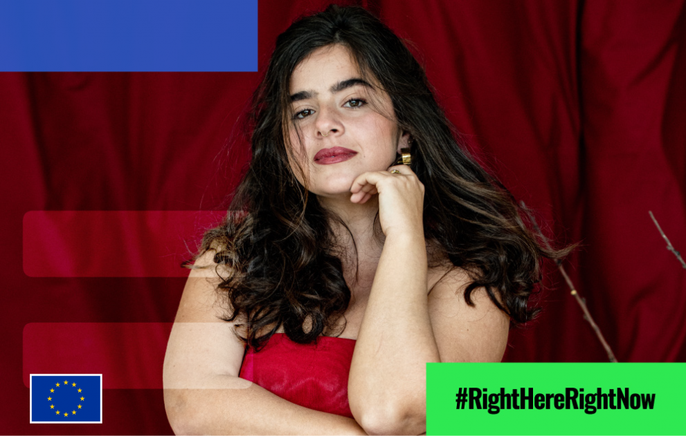 Una giovane donna con un abito rosso posa tenendo la mano sinistra sotto il mento  #RightHereRightNow  Parità di genere